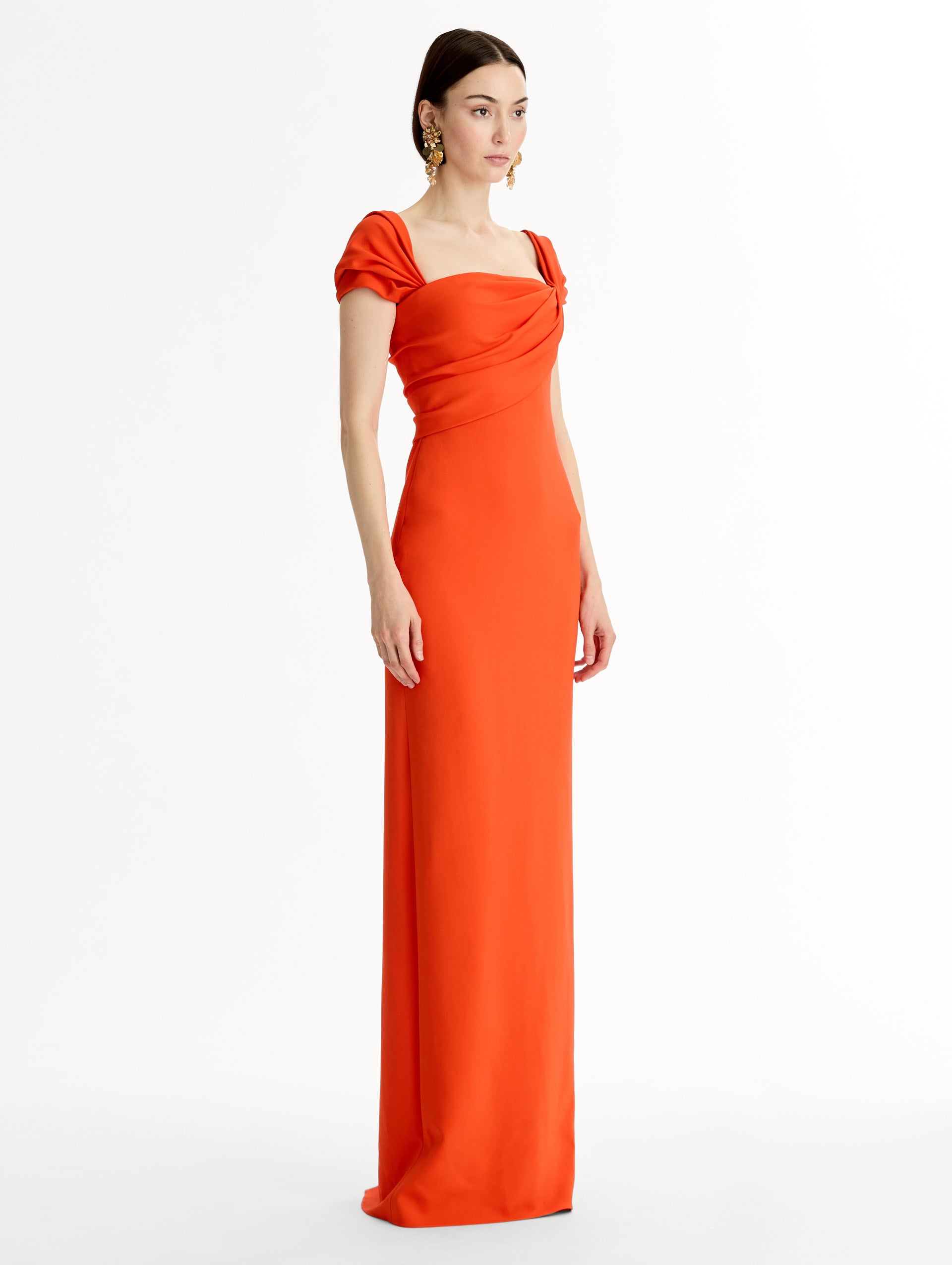 Fluid stretch cady gown with sculptural draping along neckline and shoulders. Short sleeve, column silhouette . Side View. 