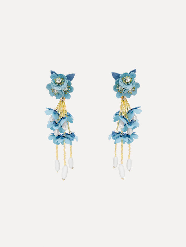Tonal blue petals form a soft gradient in floral drop earrings, accented with delicate beaded fringe. Finished with white drops.