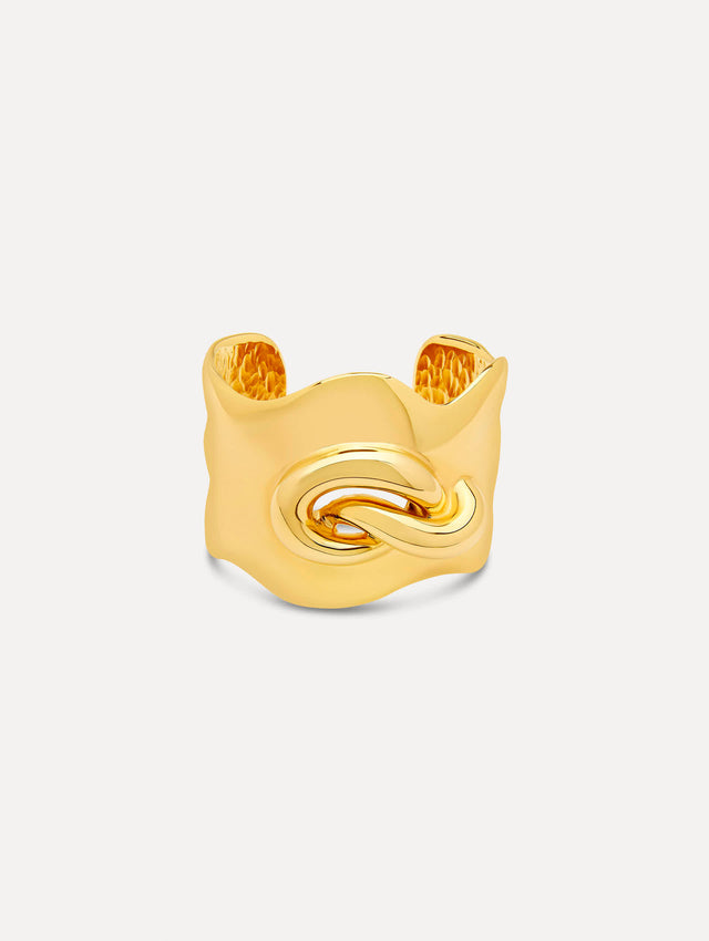 Sculptural gold cuff features a twisted abstract interpretation of the Oscar “O” emblem with an undulating curve and polished finish 