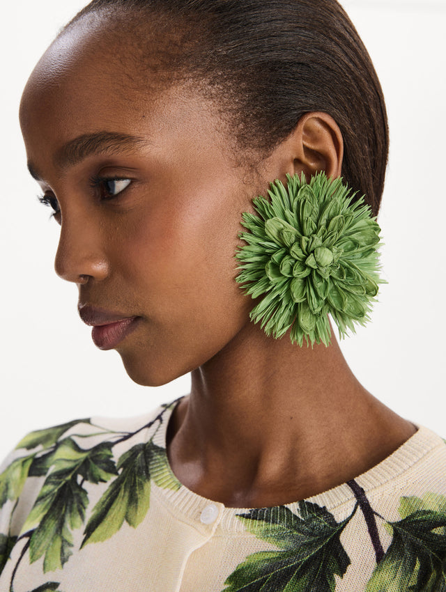 The Raffia Flower Clip-On Earrings in Green. Front view.