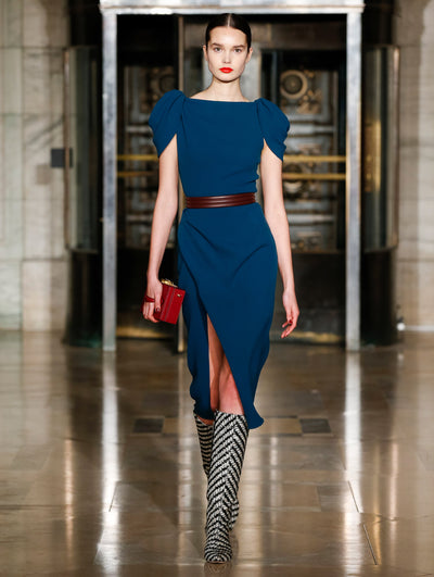 A model wears a navy dress and dark brown belt