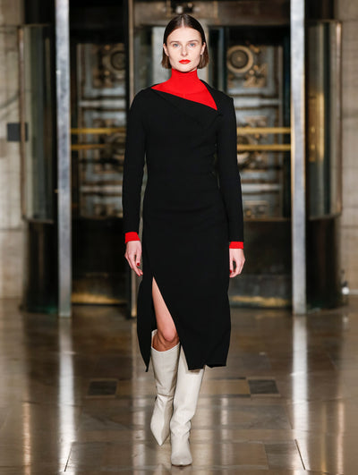 A model wears a black dress with red turtleneck