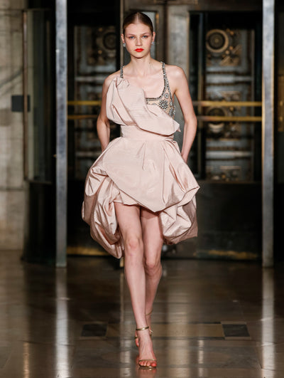 A model wears a nude dress with a sparkly silver top