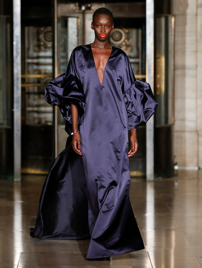 A model wears a black silk caftan with a slit down the middle top