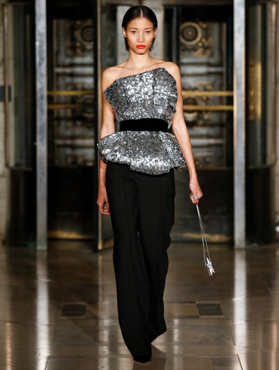 A model wears a sparkly top with black pants