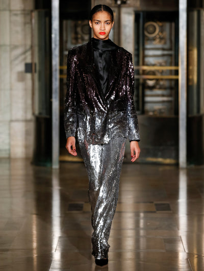 A model wears a sparkly suit set and silk blouse