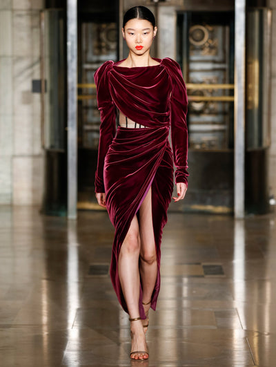 A model wears a burgundy velvet dress