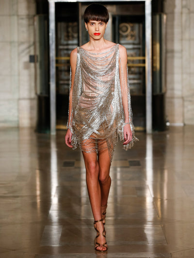 A model wears a silver fringe cocktail dress