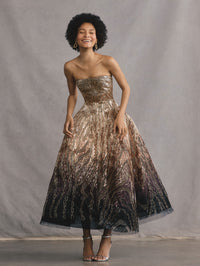 The model is wearing a strapless beaded sequin moire ombre gown.