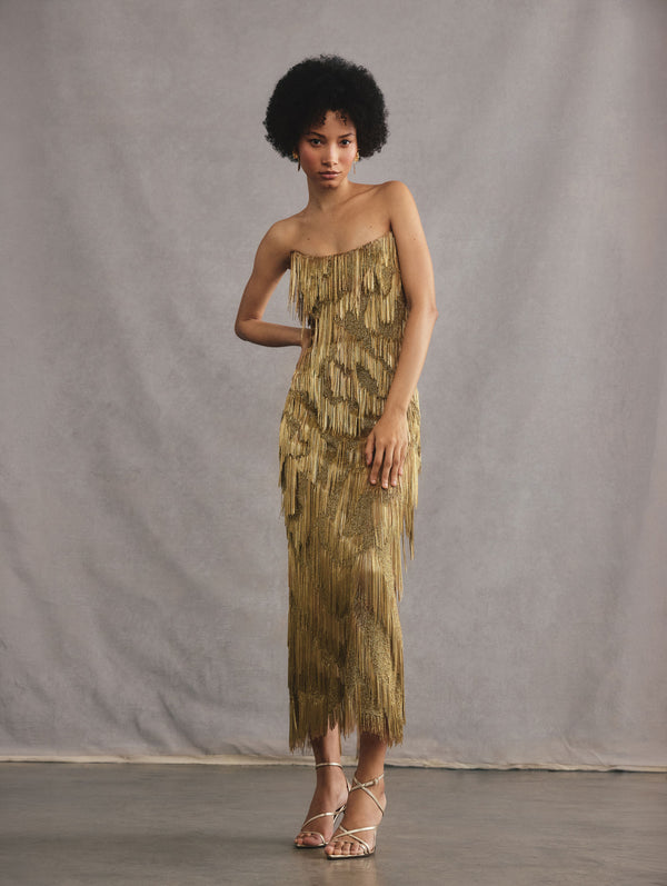 The model is wearing a gold strapless chain moire embroidered cocktail dress.