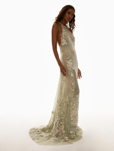 Model is wearing green sequin dress with floral embroidery. 