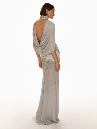 Back view of model wearing silver dress with draped open back. 