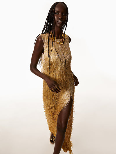 Model is wearing gold beaded dress with a gold leaf necklace. 