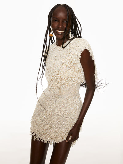 Model is wearing pearl beaded dress with white and gold bell flower earrings. 