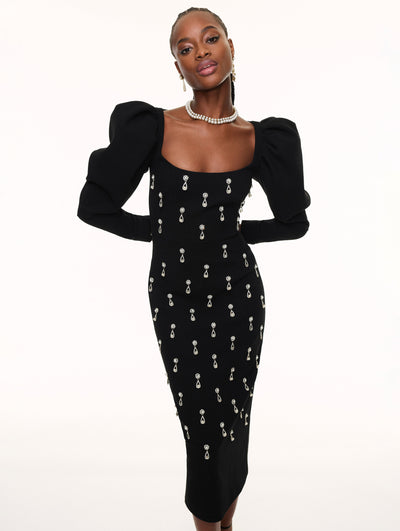 A model poses against a white backdrop in an Oscar de la Renta embroidered cocktail dress.