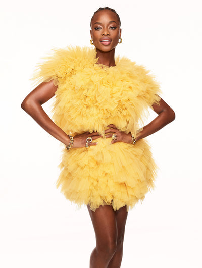 A model poses against a white backdrop in an Oscar de la Renta yellow tulle dress.