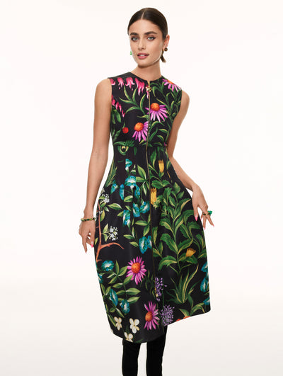 A model poses against a white backdrop in an Oscar de la Renta floral midi dress.