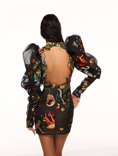 A model poses against a white backdrop in an Oscar de la Renta embroidered cocktail dress.