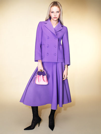 The model is wearing a purple matching jacket and full-length skirt. 
