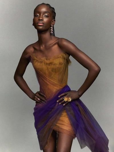 A model poses against a grey backdrop in an Oscar de la Renta tulle cocktail dress.