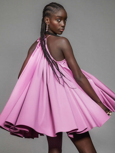 A model poses against a grey backdrop in an Oscar de la Renta pink cocktail dress.