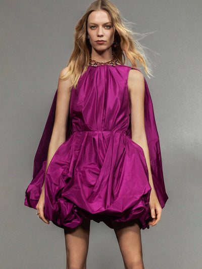A model poses against a grey backdrop in an Oscar de la Renta pink cocktail dress.