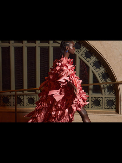 A model walks in an Oscar de la Renta pink ribbon detail caftan. 
