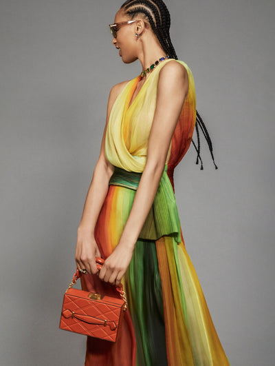 A model poses against a grey backdrop in an Oscar de la Renta abstract gown. 