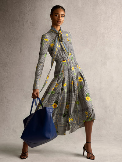 The model is wearing a black and white checkered dress with yellow flowers. 