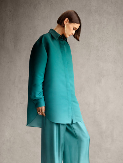 The model is wearing a teal ombre shirt jacket and matching pants. 