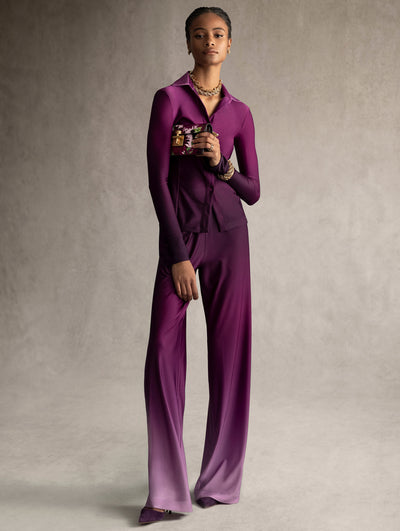 The model is wearing a matching purple ombre shirt and pant set. 
