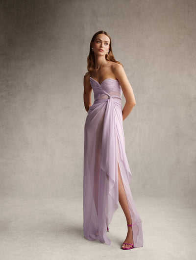 The model is wearing a strapless lilac dress. 