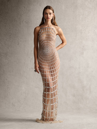 The model is wearing a strapless evening gown with a spiderweb sequin detailing throughout. 