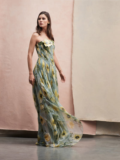 The model poses in a strapless chiffon dress in light blue with yellow flowers, and a flower applique on the top side.