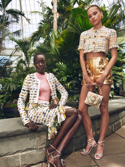 Two models pose in a green house in Oscar de la Renta tweed sets. 
