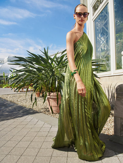 A model poses outside in an Oscar de la Renta green lame gown. 