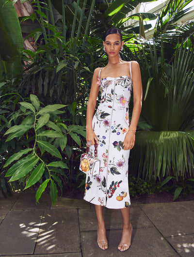 A model poses in a green house in an Oscar de la Renta printed leather cocktail dress.