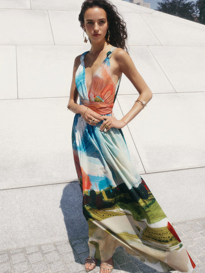 The model is wearing a crisp cotton maxi dress, which has been covered in the season's abstract landscape print. 