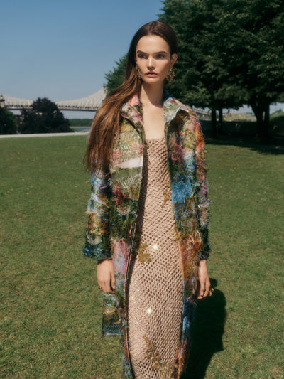 The model is wearing a hand painted fil coupe coat over a long gold dress. 