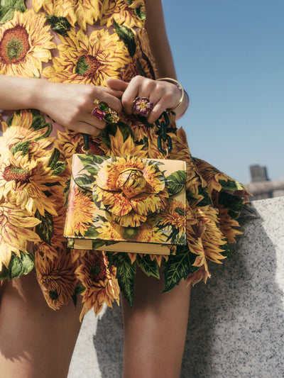 The model is carrying the signature TRO bag in a sunflower print. 