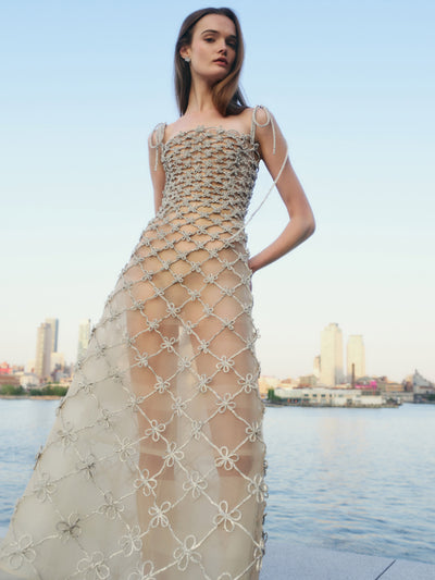 The model is wearing a tulle gown with crystal embellishments. 