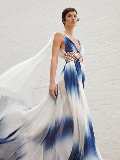 A model wears a blue and white dress with cutouts in the middle