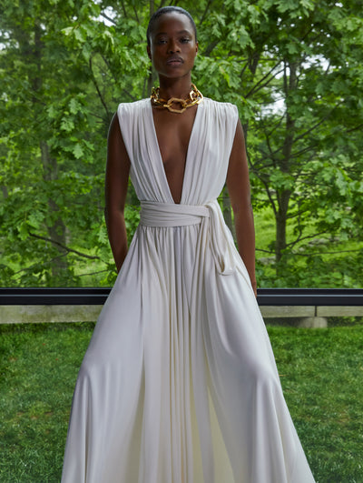 A model wears a white dress with a low slit on the chest