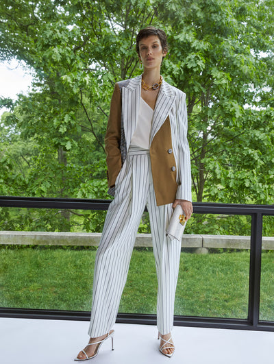 A model wears a black and white striped pantsuit set with beige accents