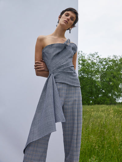 A model wears a houndstooth set with a one shoulder top and matching bottoms