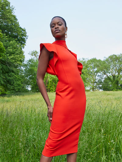 A model wears an orange red dress with ruffles