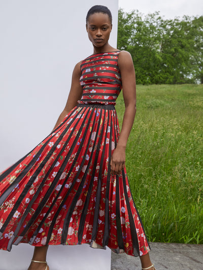 A model wears a dress with a red flower print and black stripes