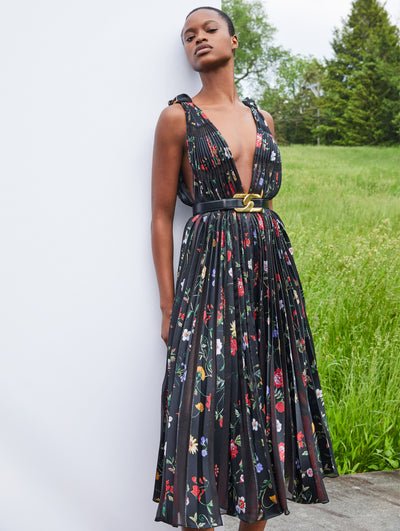 A model wears a black dress with red purple yellow flower print