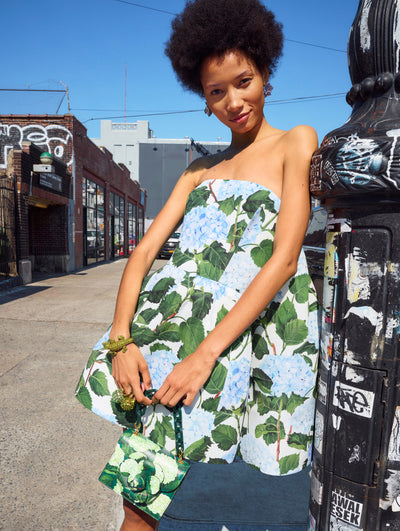 A model poses outside in an Oscar de la Renta hydrangea floral mini dress.