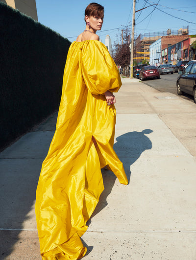 A model poses outside in an Oscar de la Renta yellow gown.